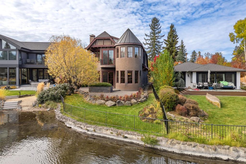 a large house with a river in front of it at Drake Park Villa in Bend