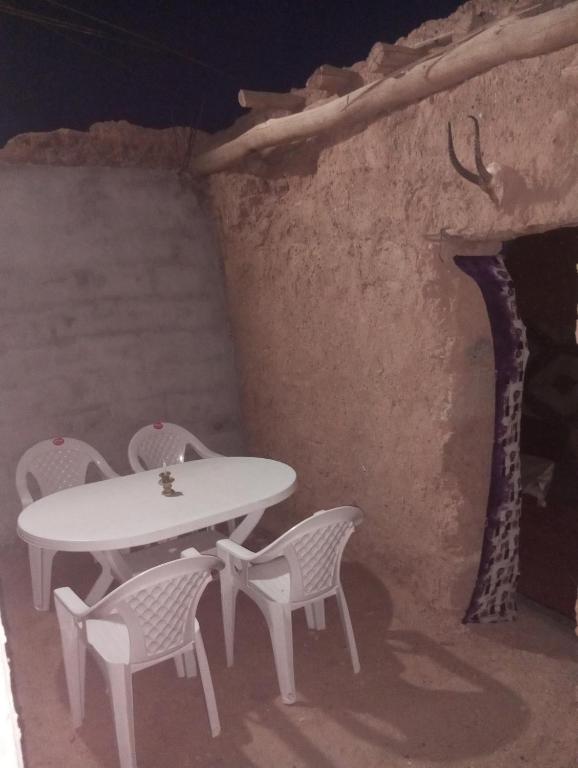 a white table and chairs in a room with a stairs at dar Brahim in Mhamid