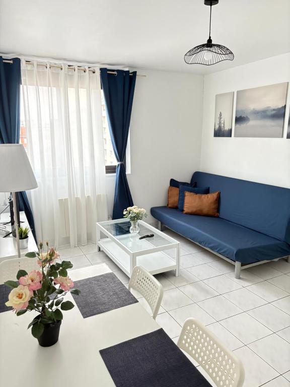 a living room with a blue couch and chairs at F3 avec Projecteur à 2 min du métro in Saint-Ouen