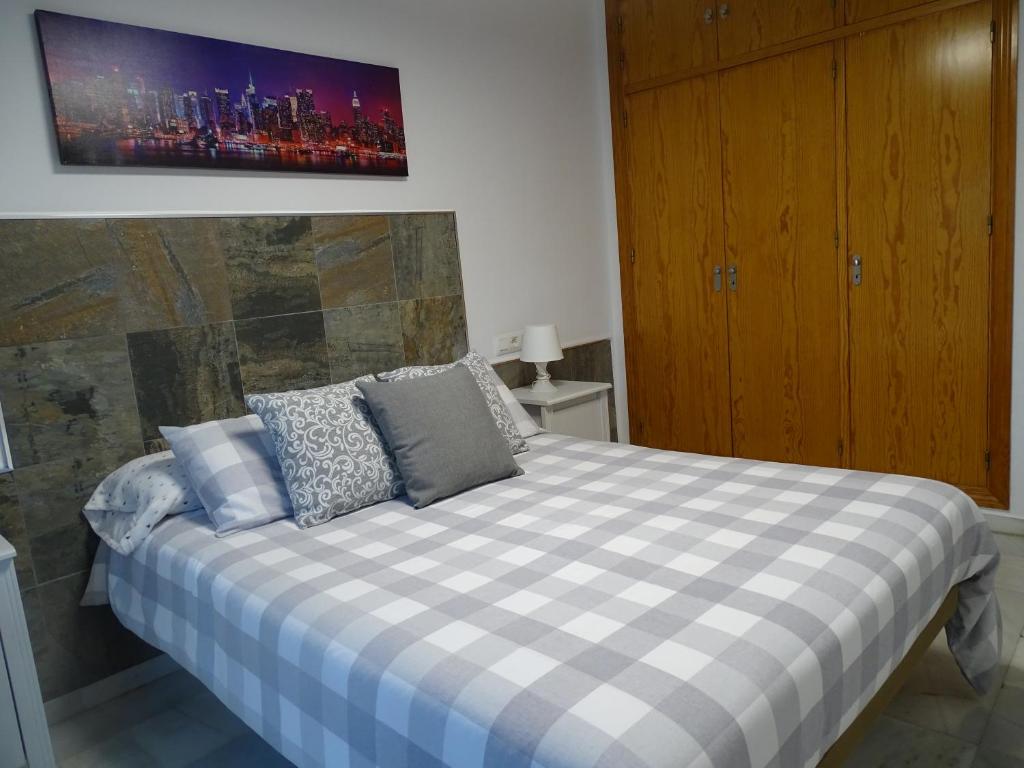 sypialnia z łóżkiem z kocem szachowym w obiekcie Apartamento Oropendola 9 w mieście El Puerto de Santa María