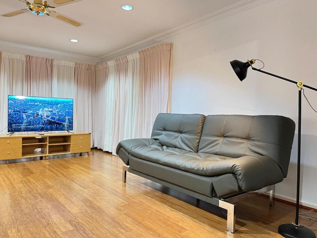 a living room with a couch and a flat screen tv at Hawker 4BR House in Canberra