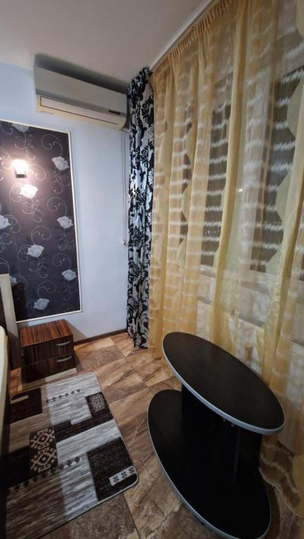 una habitación con una mesa negra y una cortina en Apartament Back, en Galaţi