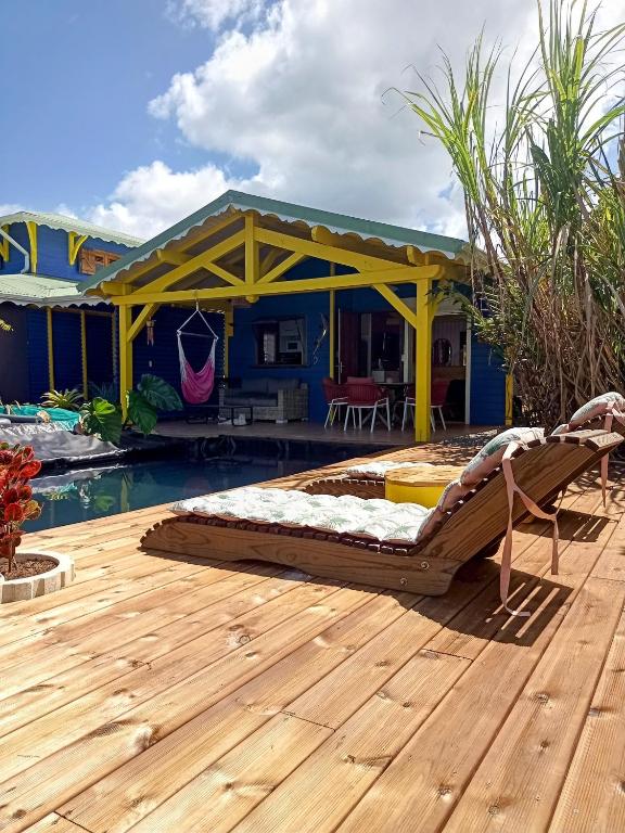 a bed on a deck next to a swimming pool at La Mare à Cuja in Sainte-Rose