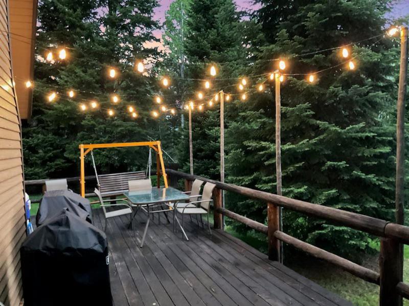 una terraza de madera con una mesa y luces. en Cub Garden, en Island Park