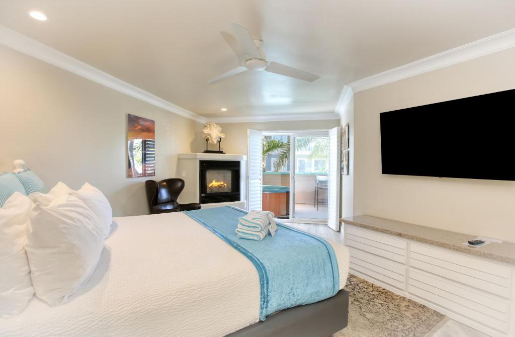 a bedroom with a large bed with a flat screen tv at SeaVenture Beach Hotel in Pismo Beach