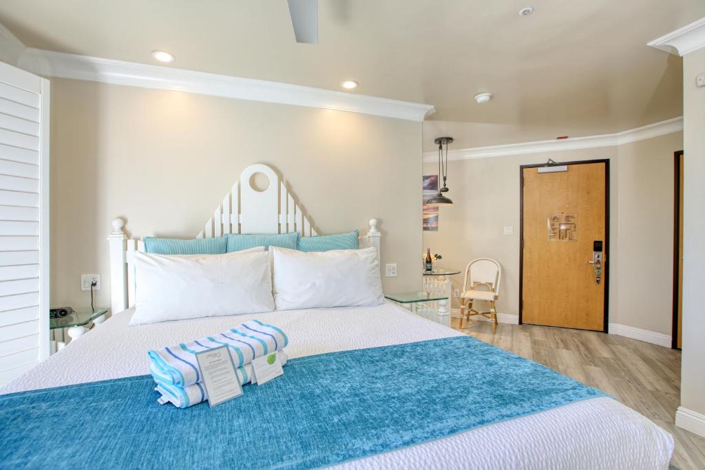 a bedroom with a large bed with a blue blanket at SeaVenture Beach Hotel in Pismo Beach
