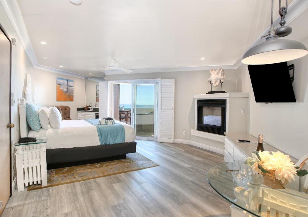 a bedroom with a bed and a fireplace at SeaVenture Beach Hotel in Pismo Beach
