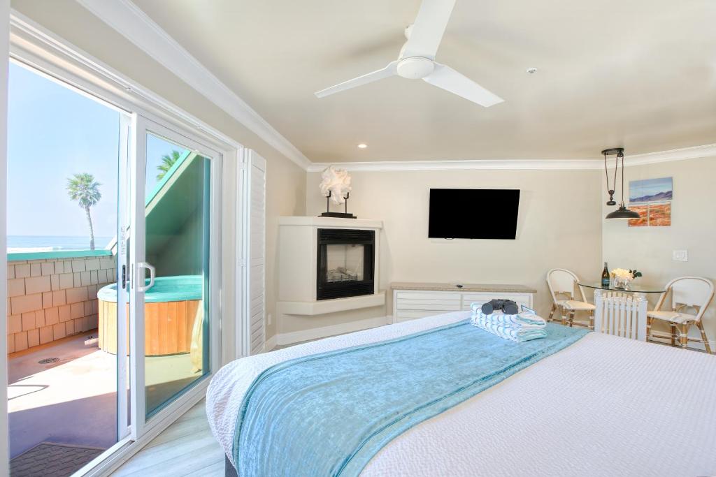 a bedroom with a large bed and a tv at SeaVenture Beach Hotel in Pismo Beach