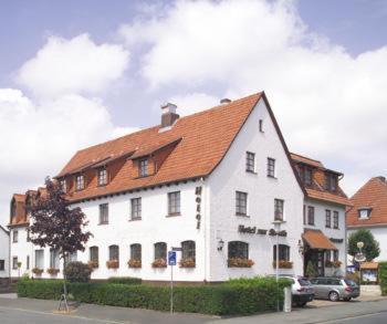 un grand bâtiment blanc avec un toit rouge dans l'établissement Hotel zur Struth, à Eschwege