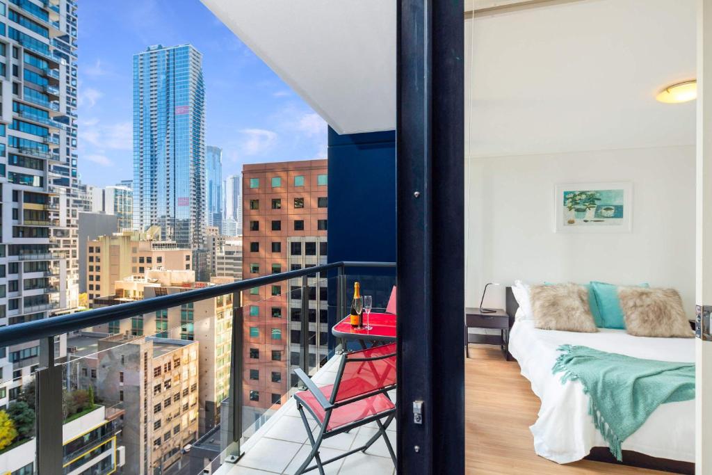 a balcony with a bed and a view of a city at Melbourne CBD Apt With A C Balcony & Pool in Melbourne