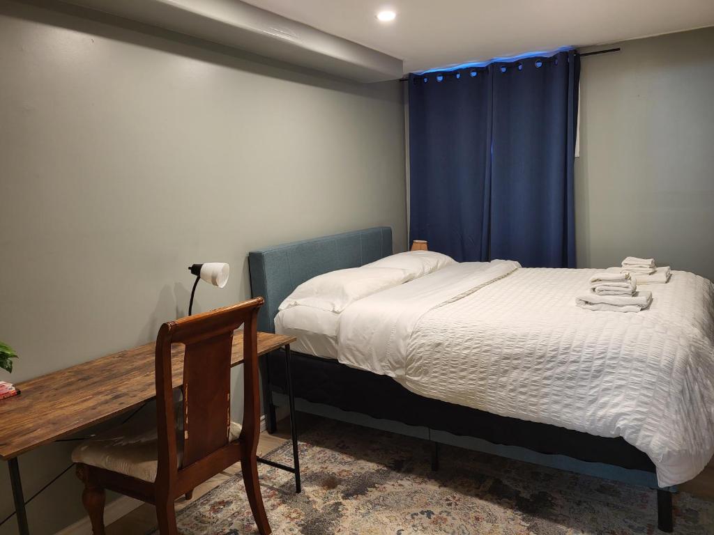 a bedroom with a bed with a desk and a blue curtain at May Flowers in Kingston