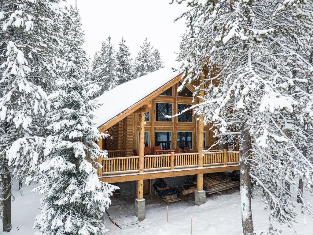 a log cabin in the woods in the snow at Lumberjack Lodge in Island Park
