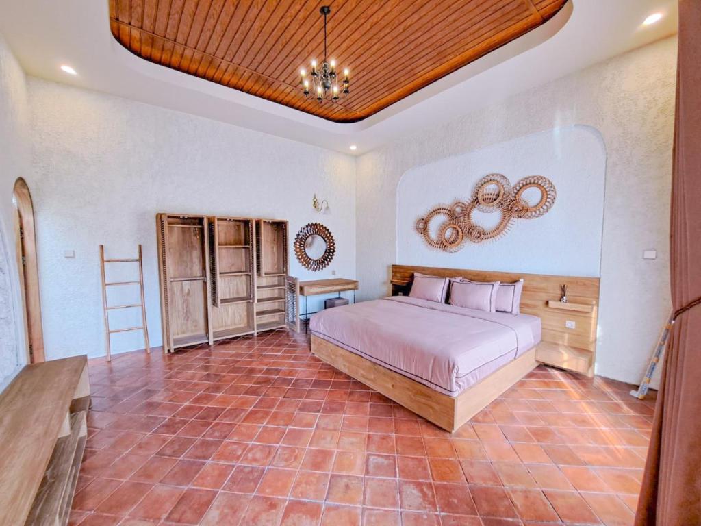 a bedroom with a bed and a wooden ceiling at Princessa by Villa Raminten in Pakem