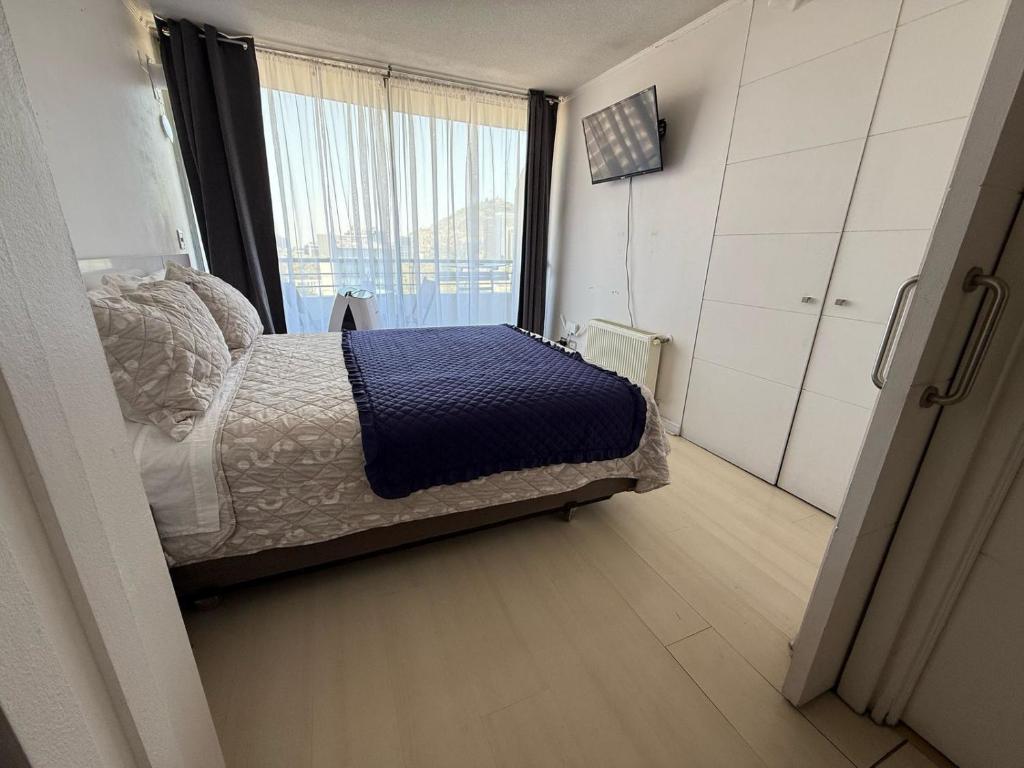 Un dormitorio con una cama y una ventana grande. en RentApartNuevadeLyon12, en Santiago