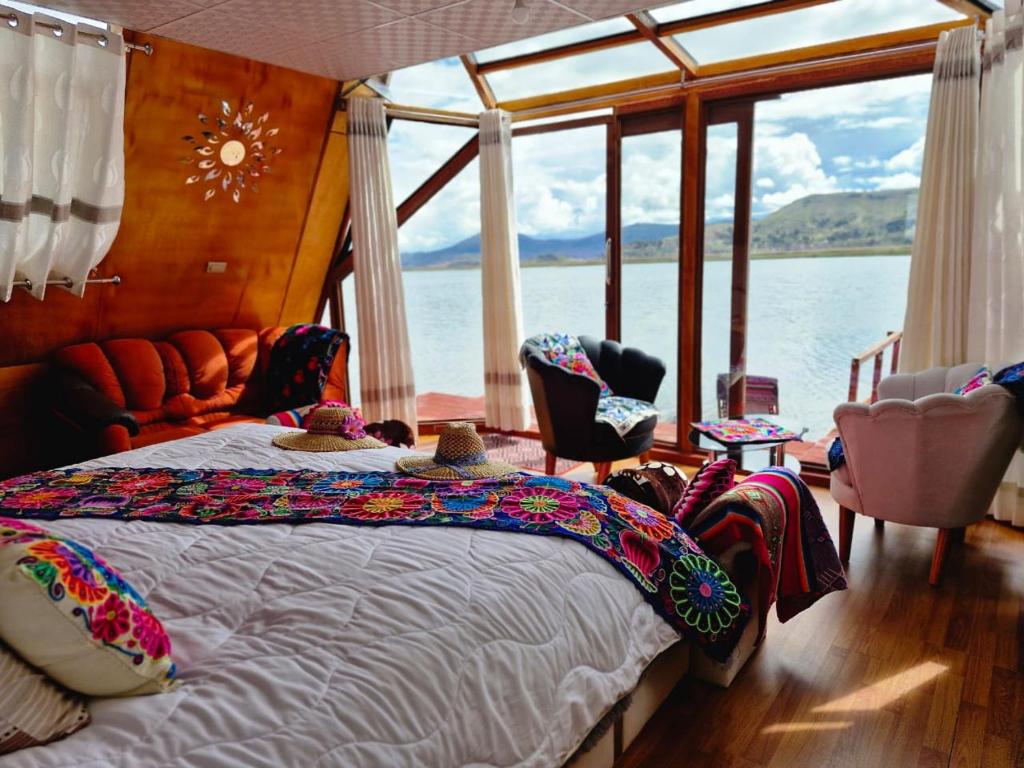 een slaapkamer met een bed en uitzicht op het water bij Titicaca Alpina HARMONY lodge in Puno