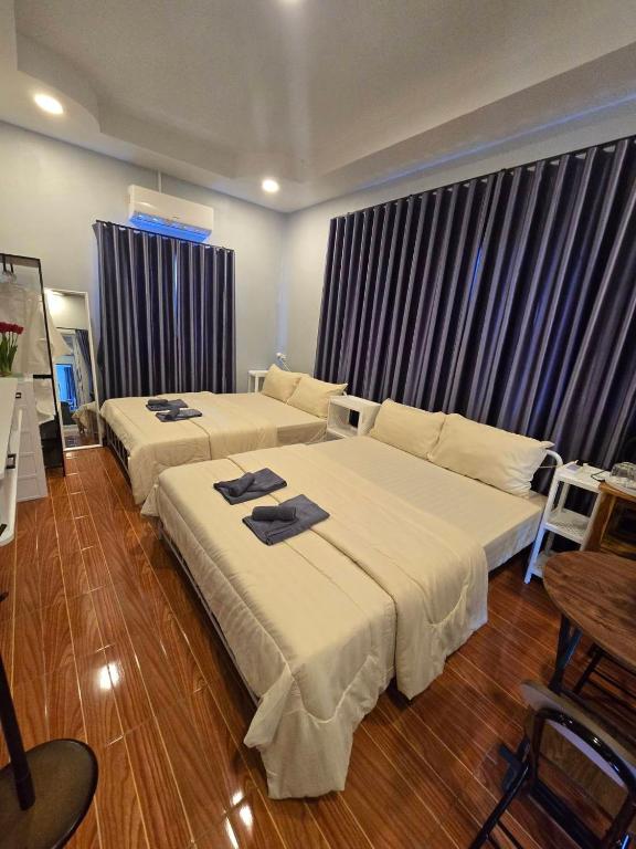 ein Hotelzimmer mit zwei Betten und einer Couch in der Unterkunft Chaba4-1 in Ban Nong Bua Noi