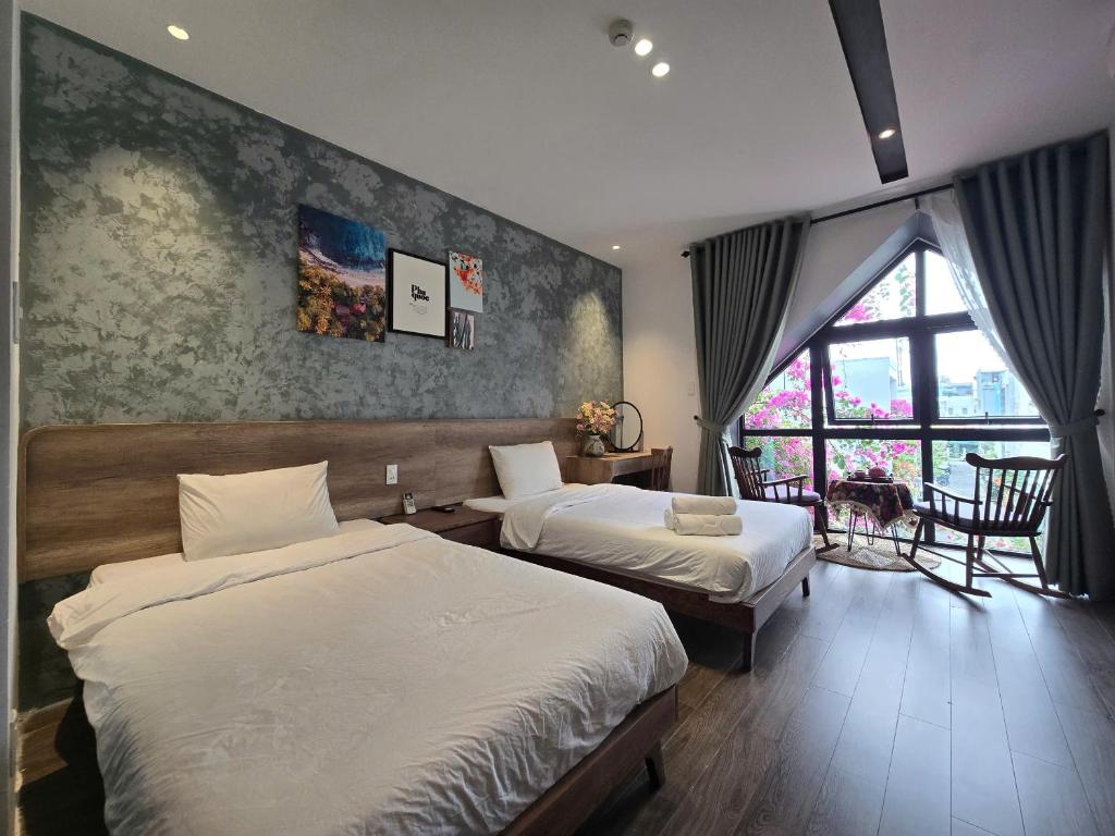 ein Schlafzimmer mit zwei Betten und einem Fenster in der Unterkunft Wings House in Đà Nẵng