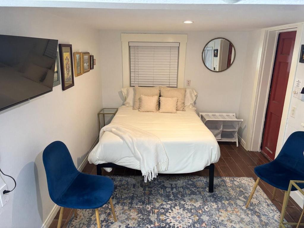 a bedroom with a bed and two blue chairs at Sunny Golden Hill Studio! Fully Stocked - near DT in San Diego