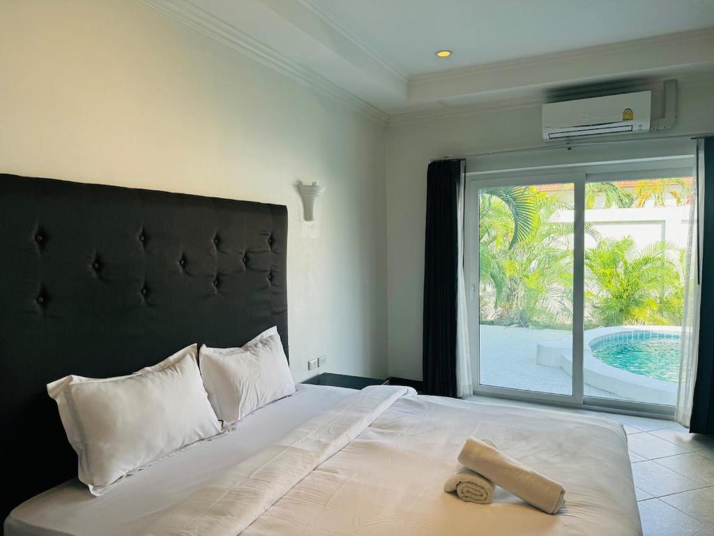 a bedroom with a large bed with a large window at Majestic Residence Seaside villa Private beach in Pattaya South