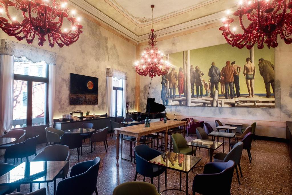 a restaurant with tables and chairs and a painting on the wall at Hotel Aquarius Venice - Ascend Collection in Venice