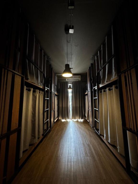 an empty room with bookshelves and a hallway with a light at Yaksa Private in Bangkok