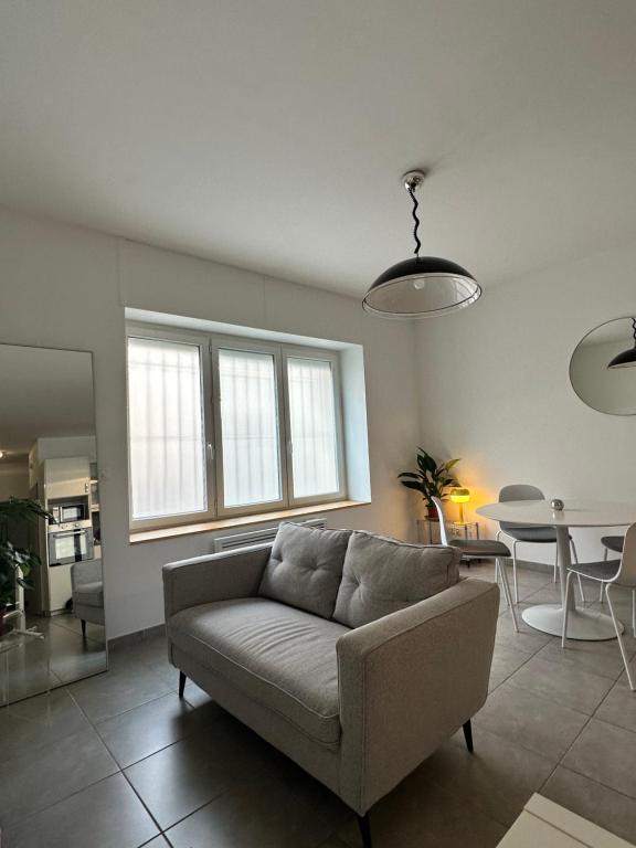 salon z kanapą i stołem w obiekcie Appartement Les Halles Narbonne w mieście Narbona