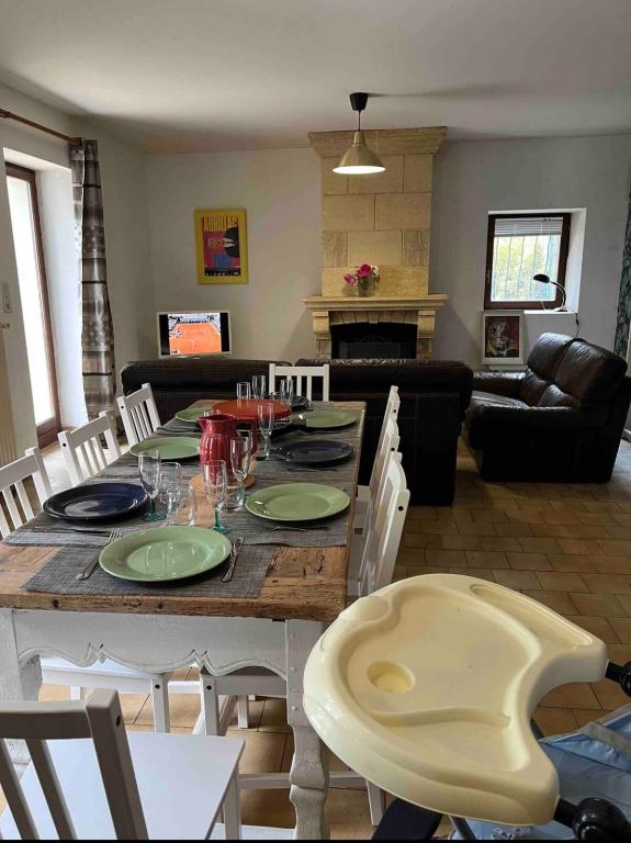 - un salon avec une table en bois, des assiettes et des verres à vin dans l'établissement La Maison du Foirail, à Aurillac