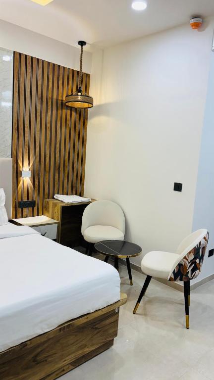 a bedroom with a bed and two chairs and a desk at Leisure Homes in Lucknow