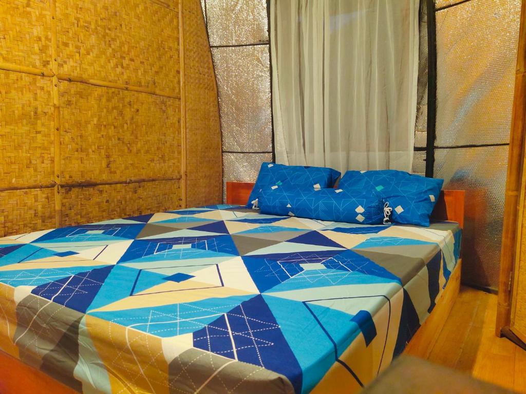 1 dormitorio con 1 cama de color azul en Kuta HomePod, en Kuta Lombok