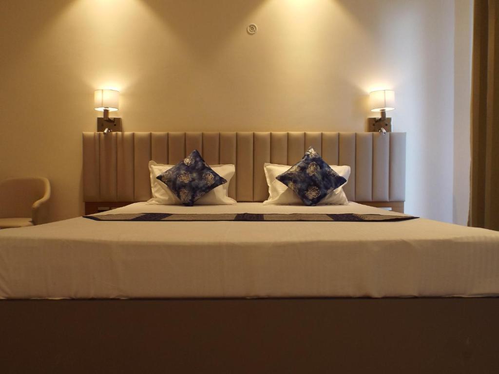 a bedroom with a large bed with blue and white pillows at Leisure Homes in Lucknow