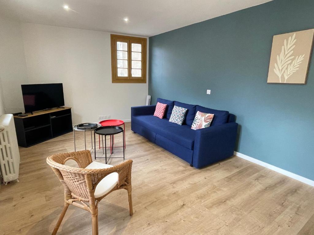 un salon avec un canapé bleu et une table dans l'établissement L'Architecte, à Figeac