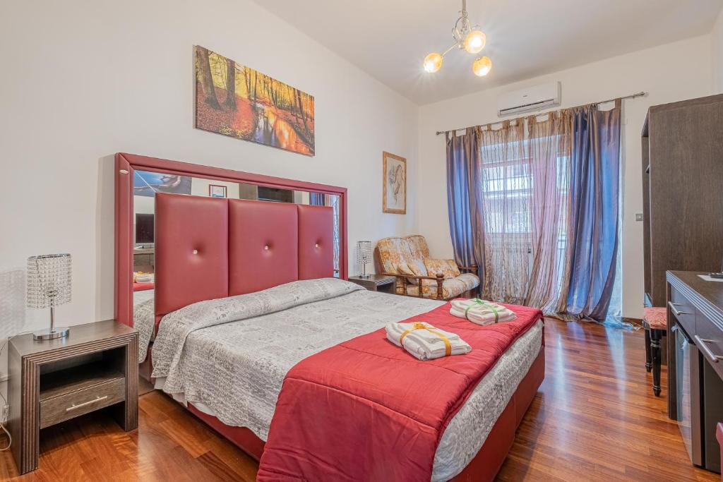 sypialnia z dużym łóżkiem z czerwonym zagłówkiem w obiekcie Bed and Breakfast Impruneta28 w Rzymie