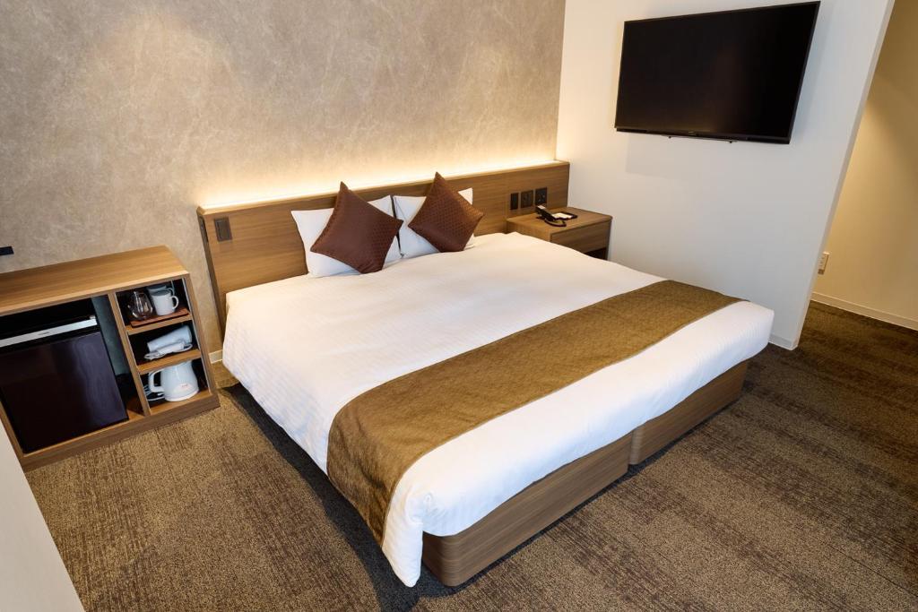 Postel nebo postele na pokoji v ubytování Ginza International Hotel
