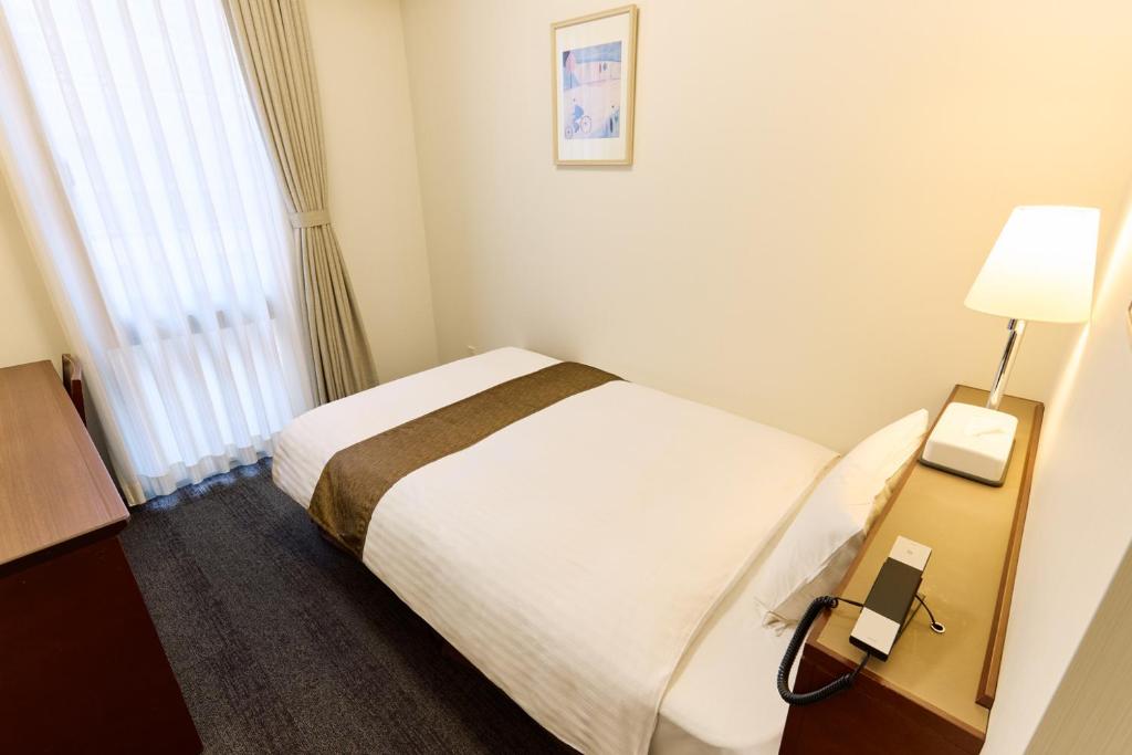 Postel nebo postele na pokoji v ubytování Ginza International Hotel