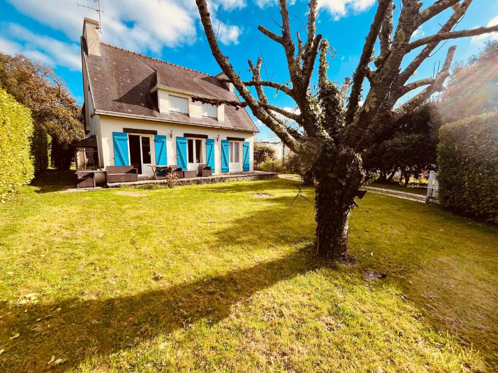 une maison avec un arbre dans la cour dans l'établissement Il y a le ciel, le soleil, et la mer 4 chambres, à Bénodet