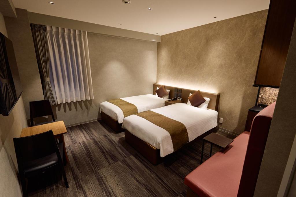 Postel nebo postele na pokoji v ubytování Ginza International Hotel