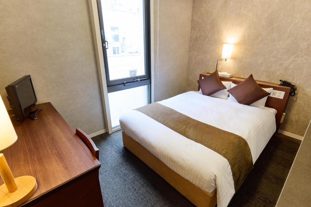 Postel nebo postele na pokoji v ubytování Ginza International Hotel
