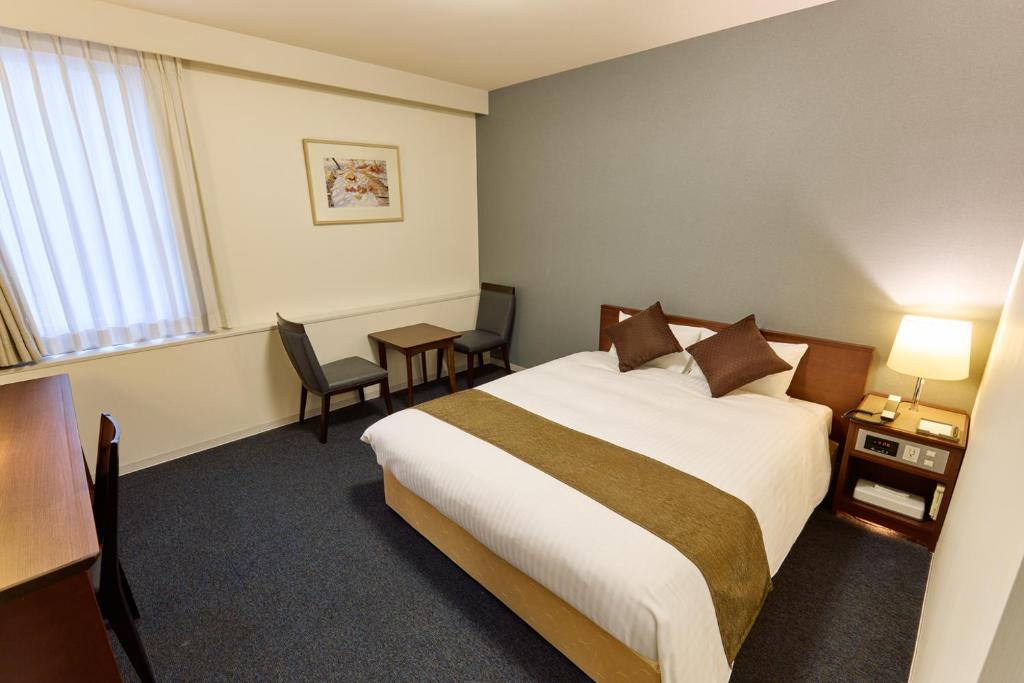 Postel nebo postele na pokoji v ubytování Ginza International Hotel