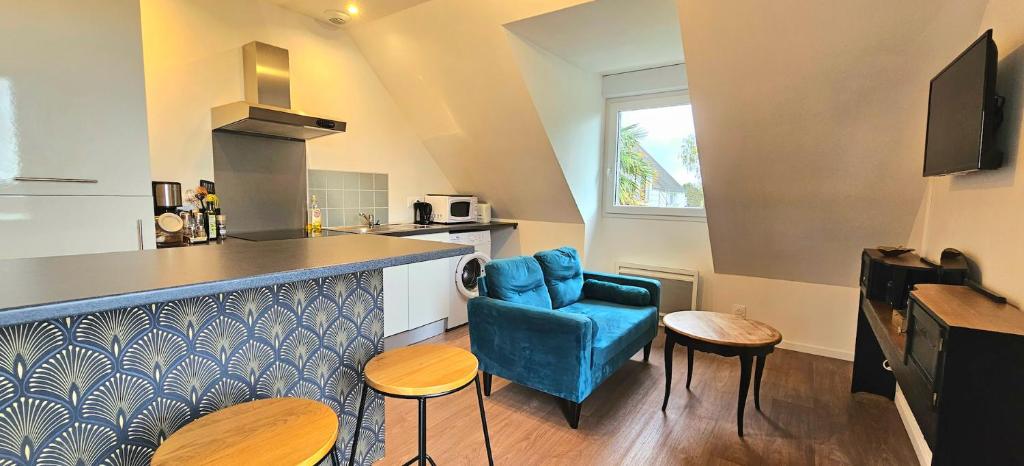 - une cuisine avec un bar et une chaise bleue dans la chambre dans l'établissement T2 avec jardin proche des plages, à Bénodet