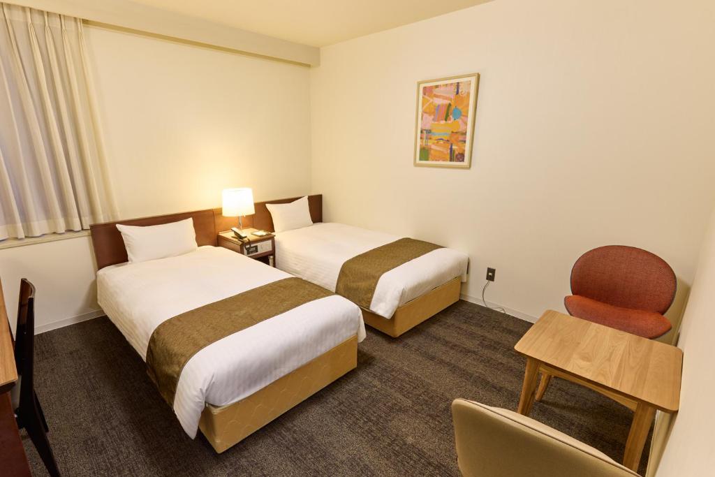 Postel nebo postele na pokoji v ubytování Ginza International Hotel