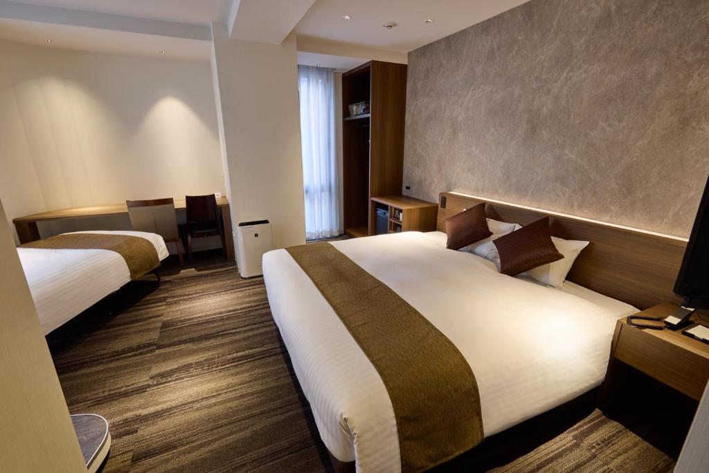 Postel nebo postele na pokoji v ubytování Ginza International Hotel
