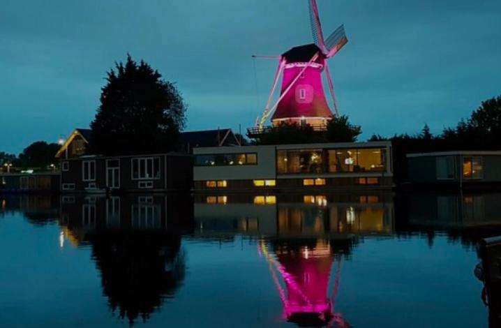 a windmill with its reflection in the water at night at Nice and cosy house close Amsterdam and airport in Badhoevedorp