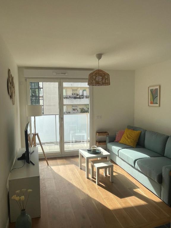 un salon avec un canapé et une table dans l'établissement New & serene II 1 bedroom appartement near La Défense Paris Parking and Fibre, à Suresnes