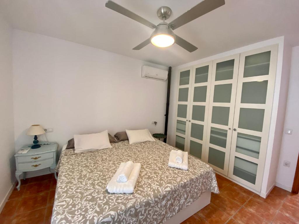 a bedroom with a bed with two towels on it at Duplex con terraza en Agua Amarga in Agua Amarga