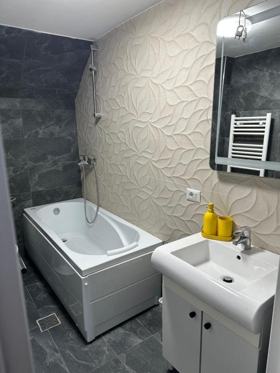 a bathroom with a white tub and a sink at Villa ANMA in Bucharest