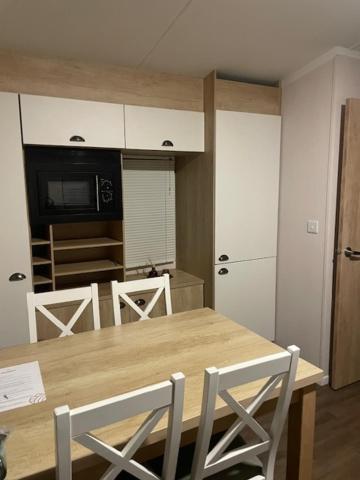 a kitchen with a wooden table with chairs and a microwave at Lakes Escapes in Lamplugh