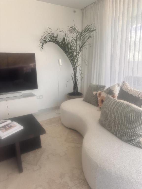 salon z białą kanapą i telewizorem w obiekcie Marbella GOLF & SEA LODGE w mieście Estepona