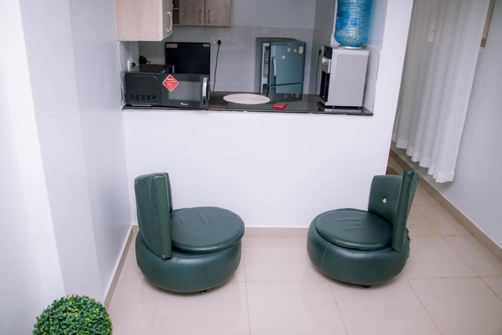 two green chairs in a room with a counter at Bellissima Homes in Kericho