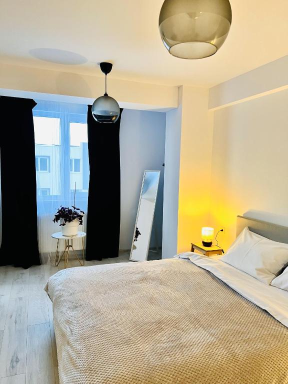 a bedroom with a large bed and a mirror at Airport Gardens Loft in Otopeni