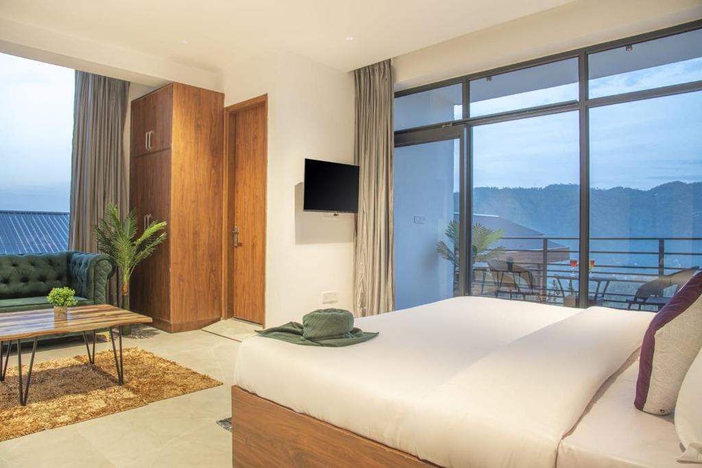 a bedroom with a large bed and a balcony at kasauli hills by Hillcrest in Kasauli